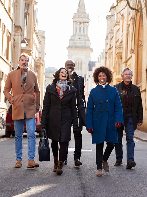 Group Of Mature Friends Walking Through City In Fall Together
