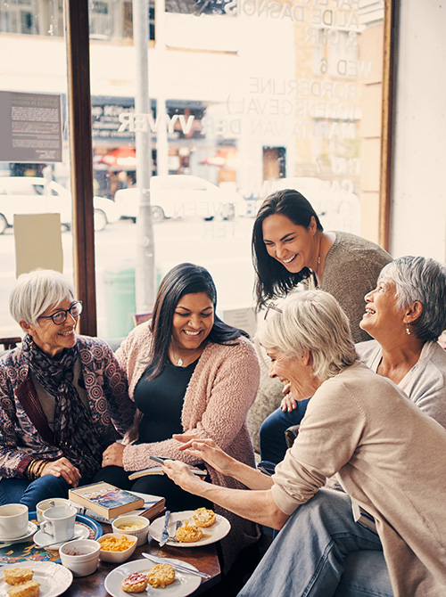 Group of diverse women smiling at cafe book club event